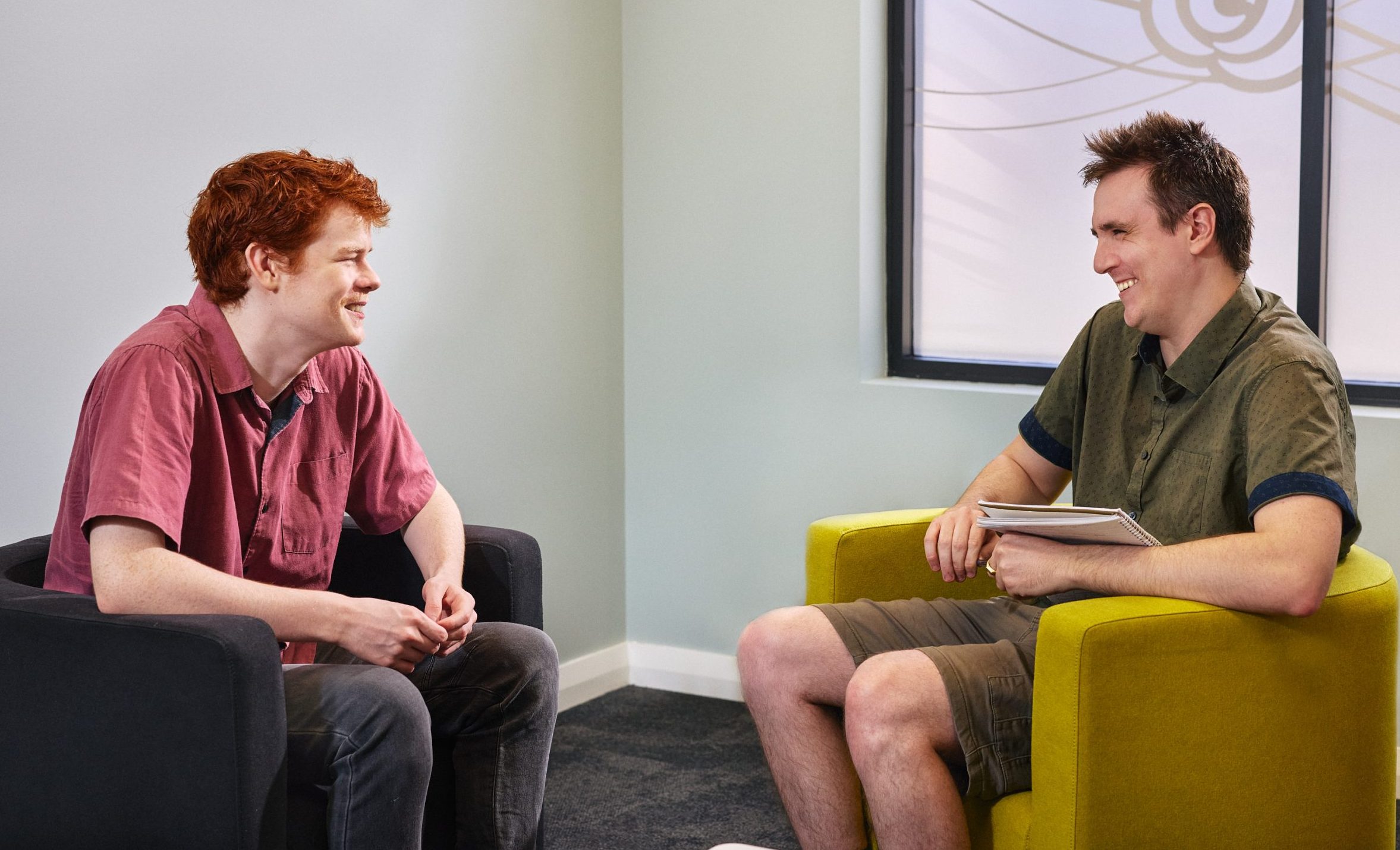 Dillon and Harry are seated together at Armadale SensesWA. The are smiling and talking.